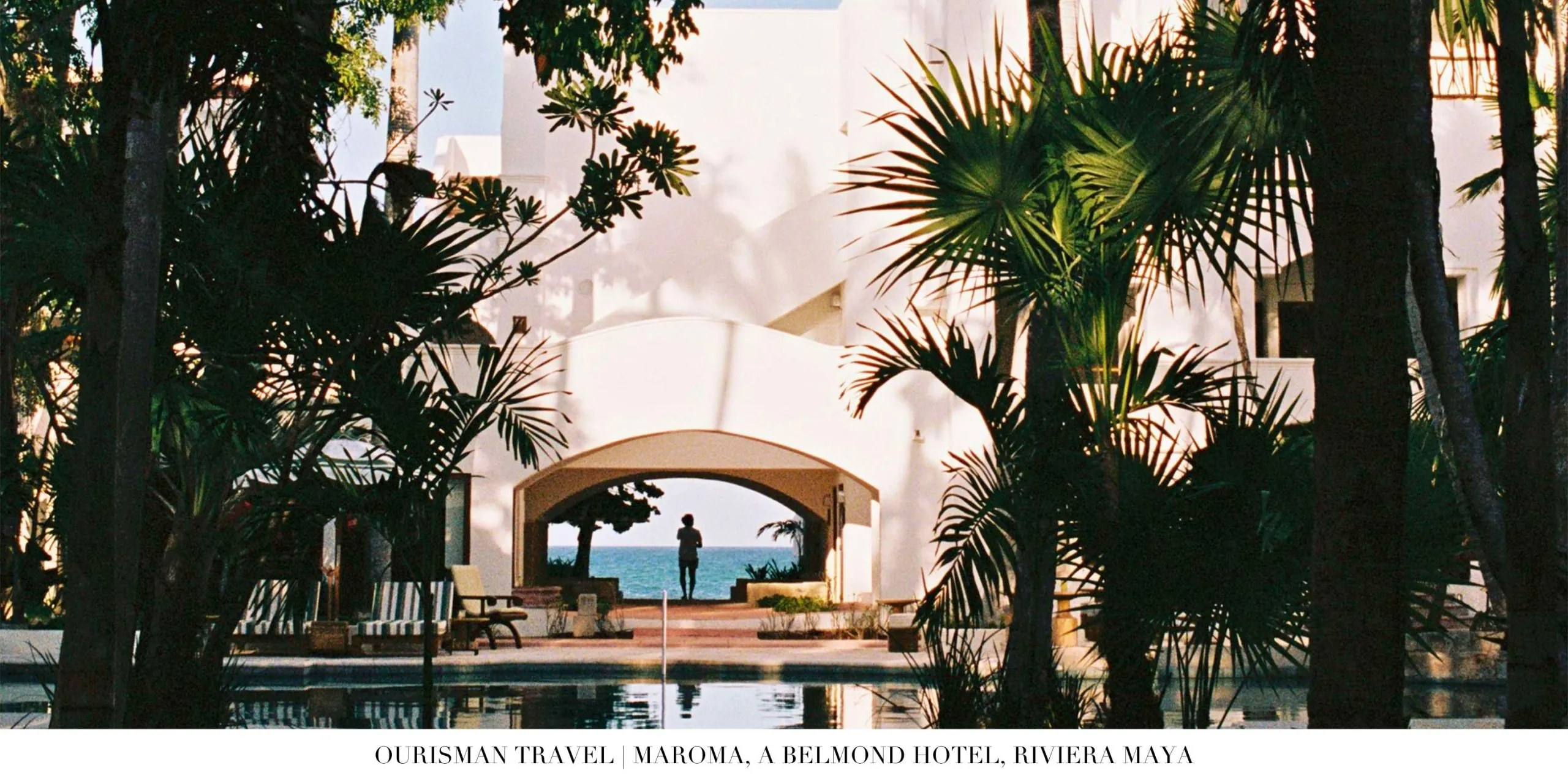 Pool area at Maroma A Belmond Hotel surrounded by palms