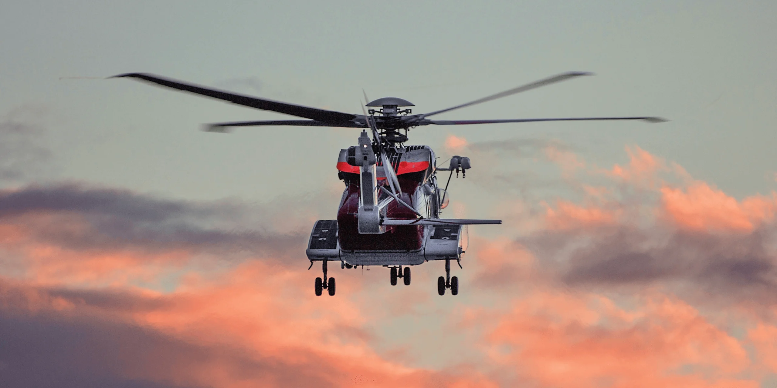 Helicopter flying at sunset over landscape
