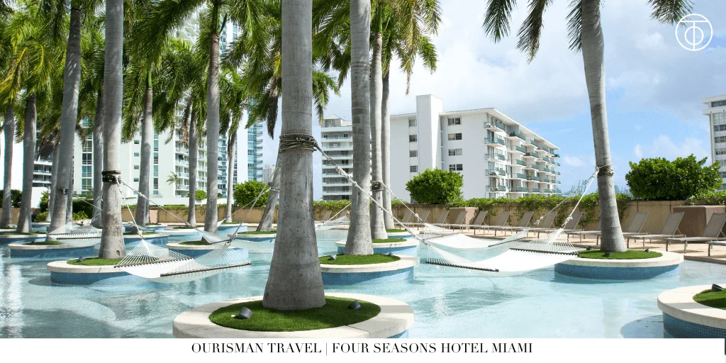 Tropical pool deck at Four Seasons Hotel Miami with palm trees.