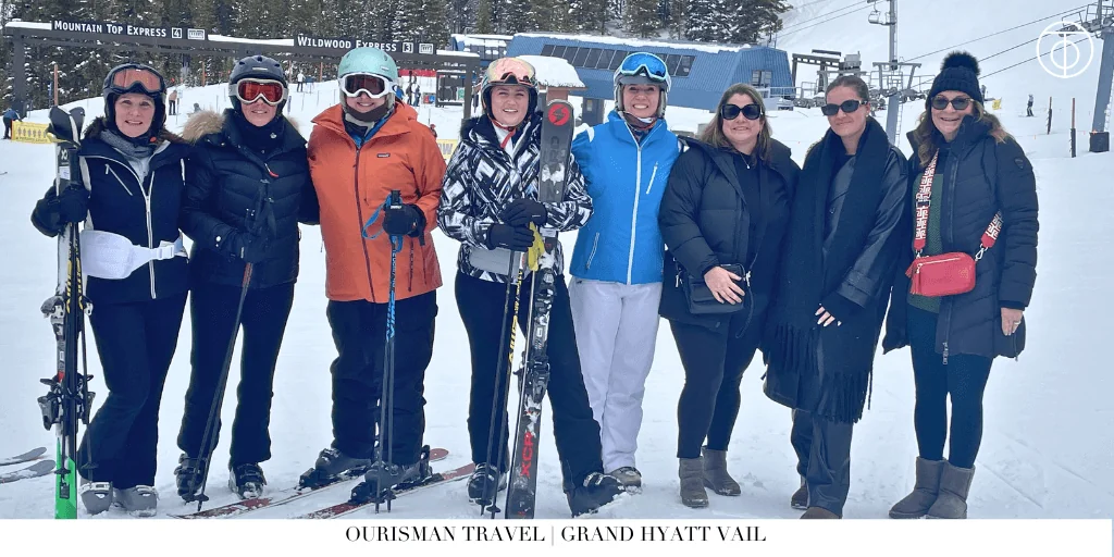 Group of travelers in ski gear standing on snowy slopes at a ski resort