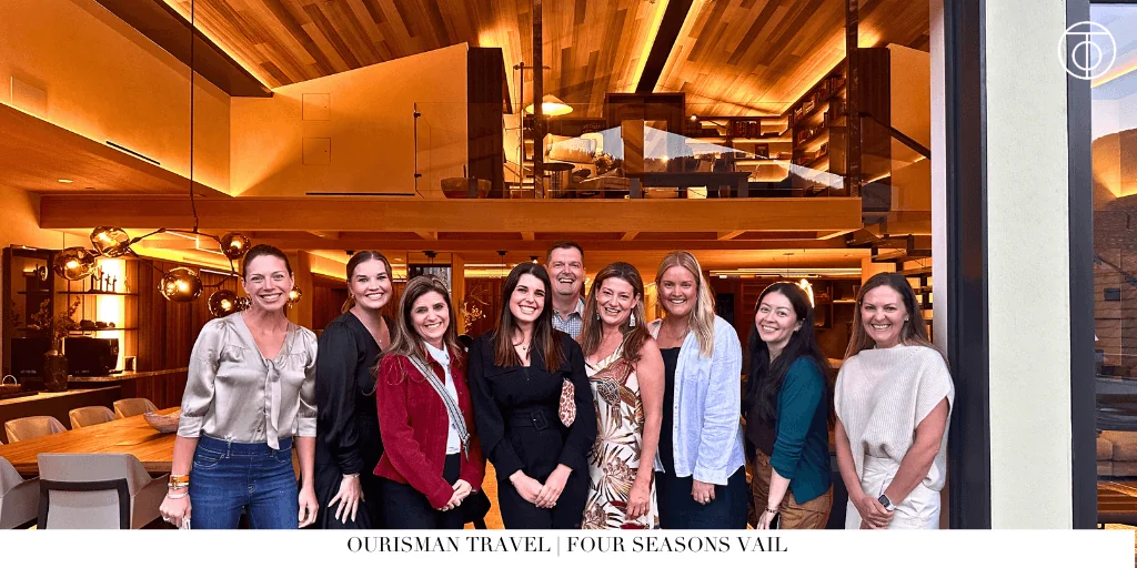 Team O members standing together inside a luxury mountain lodge lobby