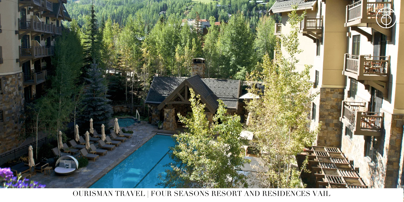 Mountain resort pool surrounded by trees and lodge buildings