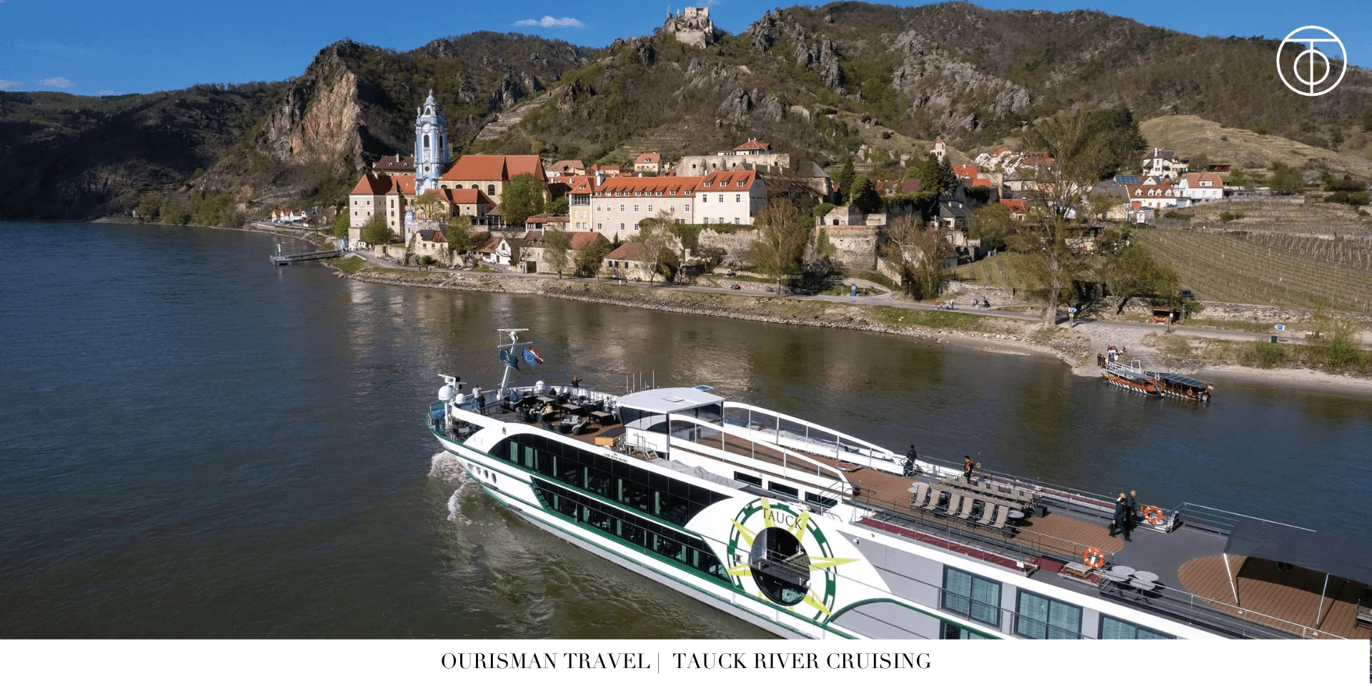 Tauck river cruise ship passing a hillside town and castle along the river