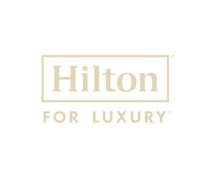 Hilton for Luxury logo representing preferred Hilton luxury travel advisors offering VIP amenities, complimentary breakfast, room upgrades, and exclusive benefits at participating Hilton luxury hotels and resorts