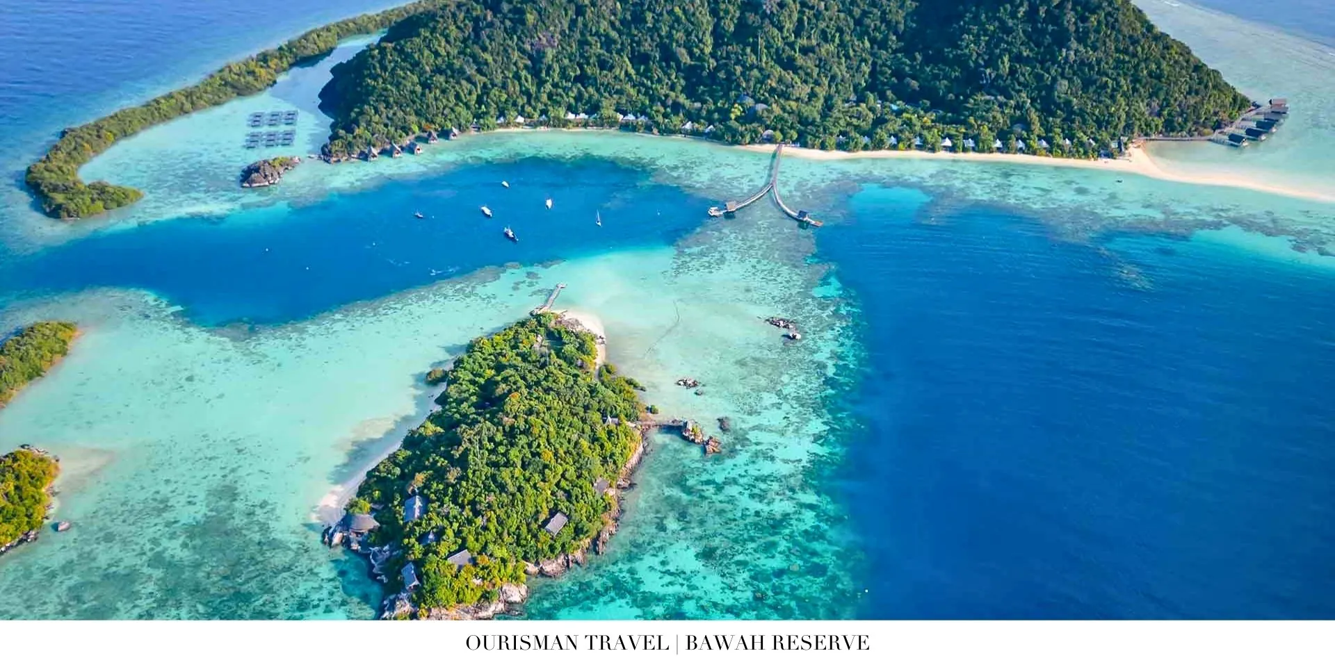 Aerial view of Bawah Reserve private island surrounded by crystal-clear lagoon and tropical jungle