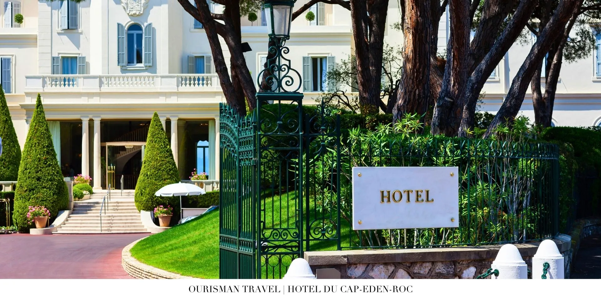 Hotel du Cap-Eden-Roc façade framed by palm trees and vibrant flowering plants
