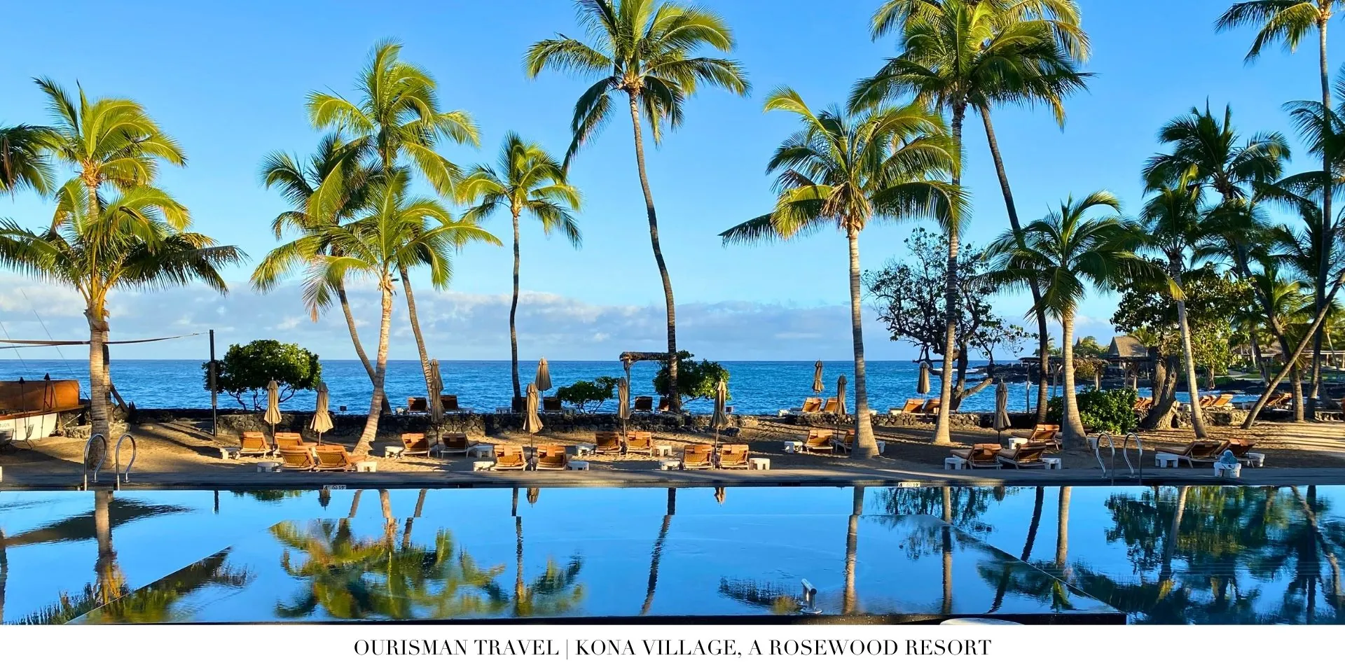 Oceanfront pool at Kona Village with lounge chairs and palm trees lining the shore