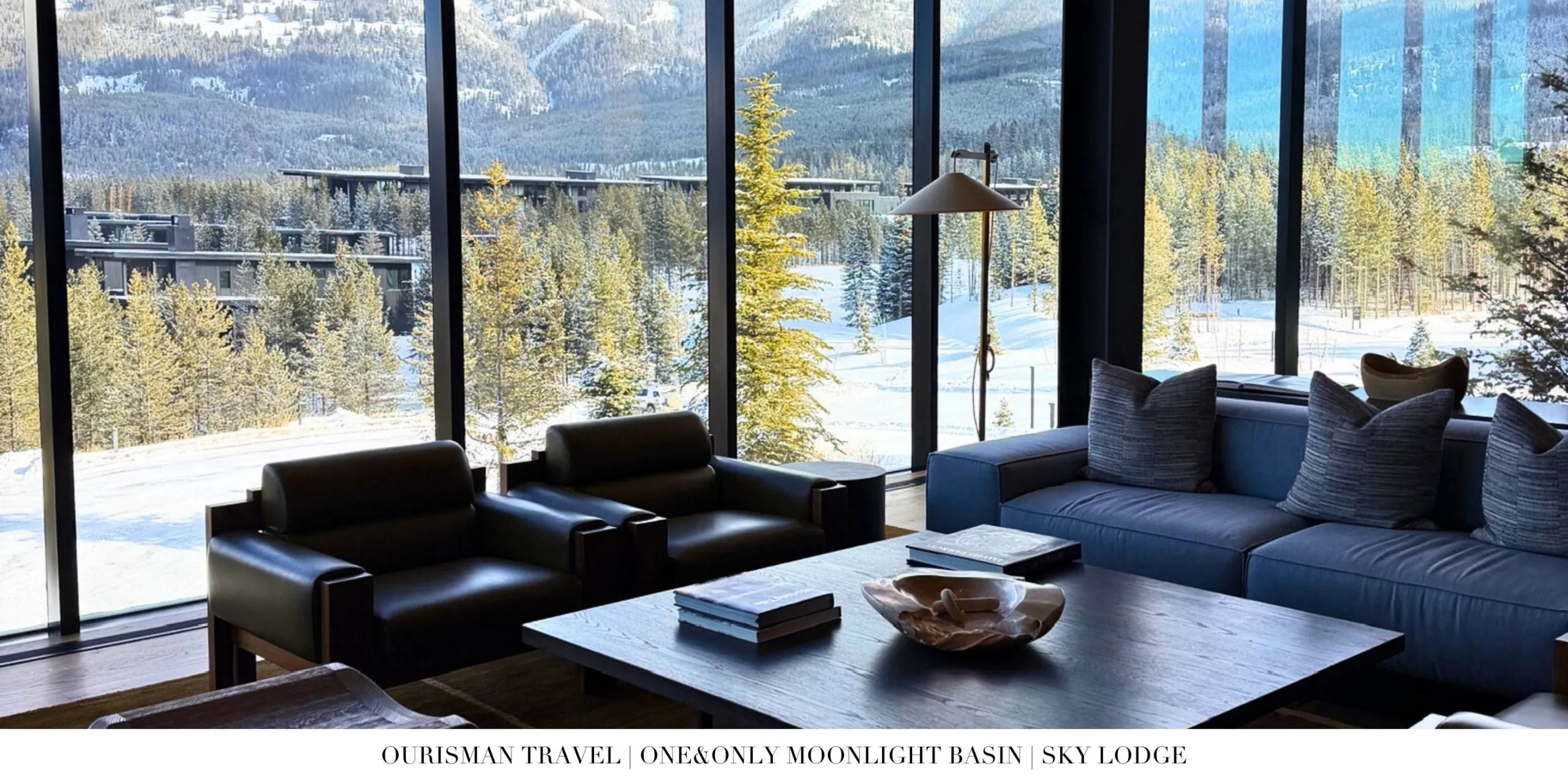 Sky Lodge lobby at One&Only Moonlight Basin with soaring ceilings, floor-to-ceiling windows, and warm wood and stone design details.