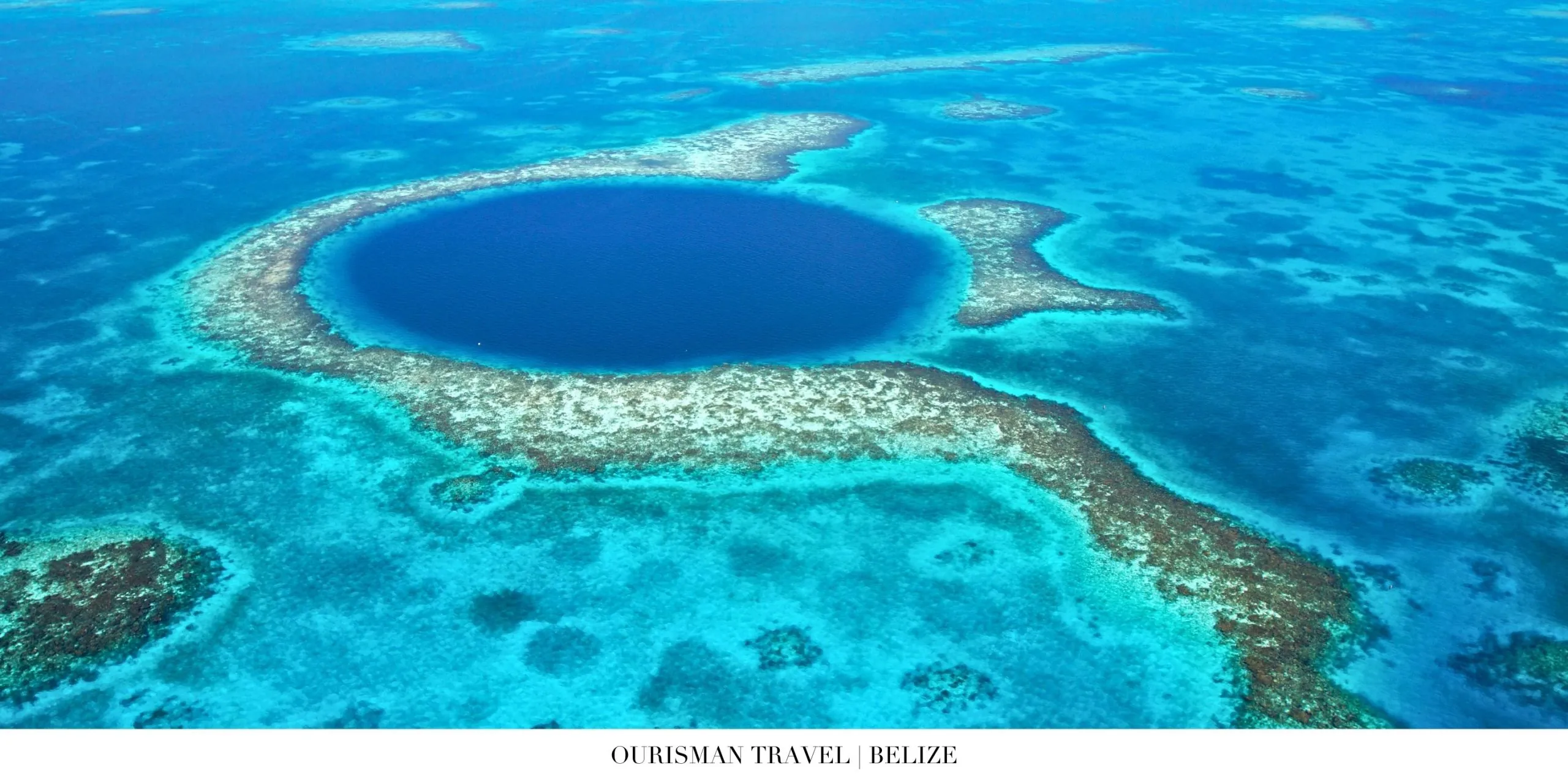 Aerial view of Belize’s turquoise waters and barrier reef islands