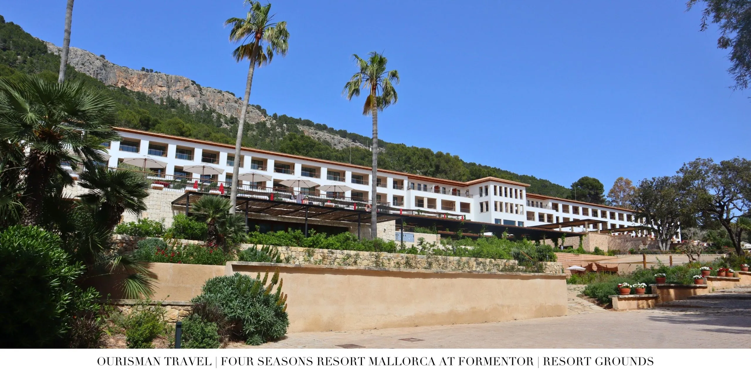 Exterior view of Four Seasons Resort Mallorca at Formentor surrounded by palm trees and mountains