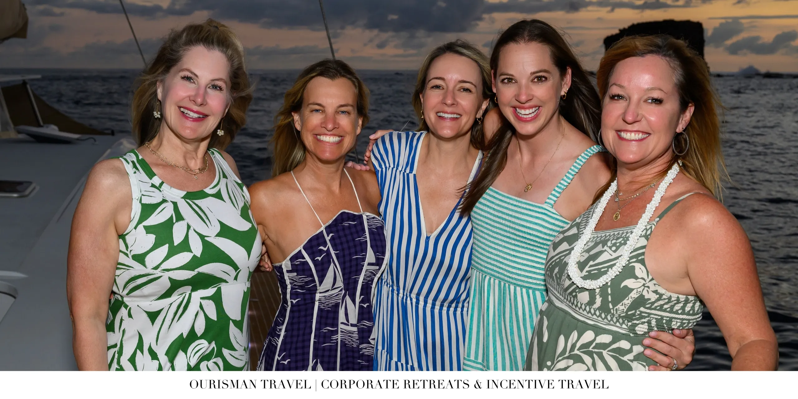 Corporate incentive travel attendees aboard a luxury catamaran at sunset