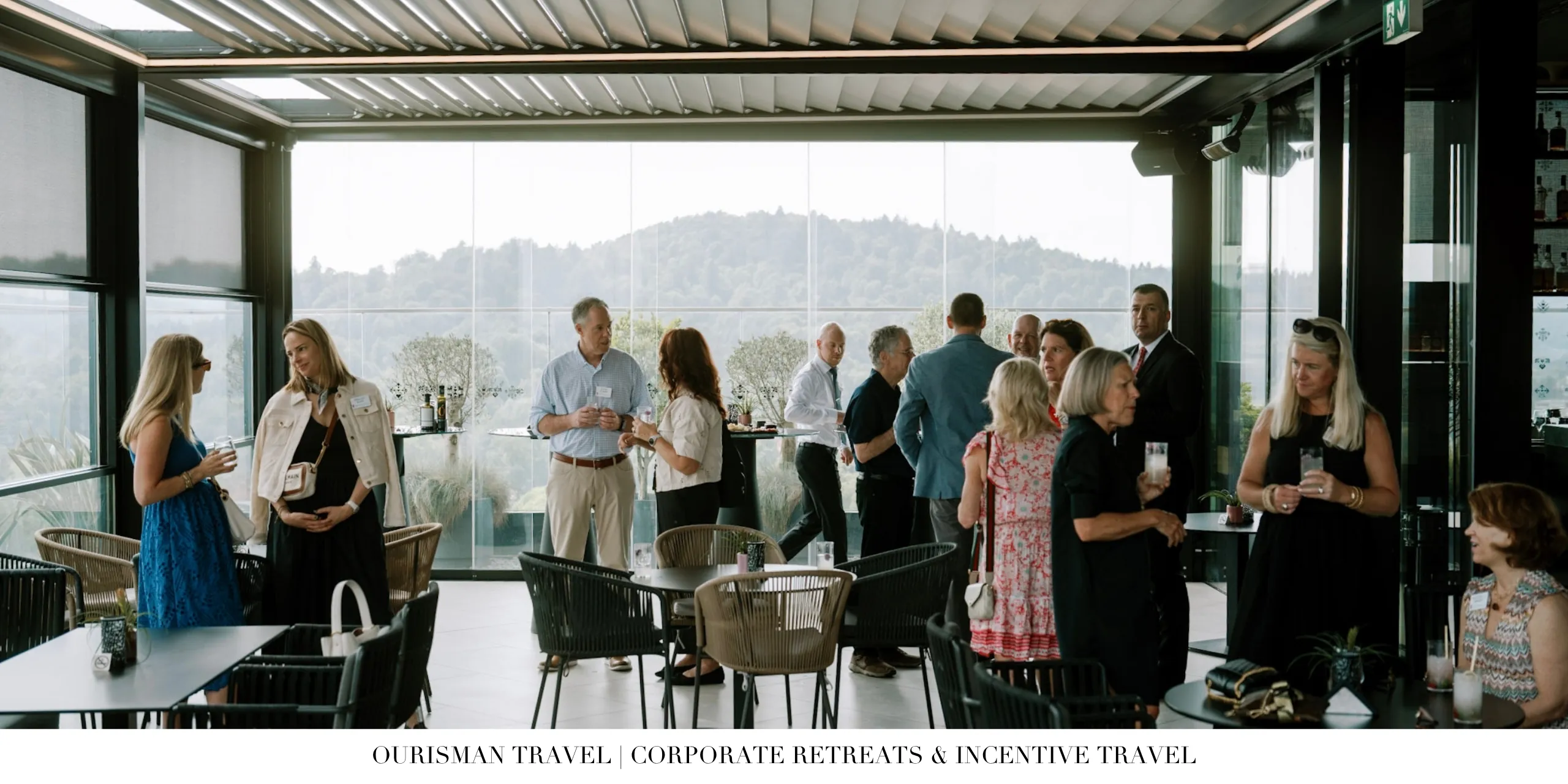 Corporate retreat attendees networking during a reception with scenic views