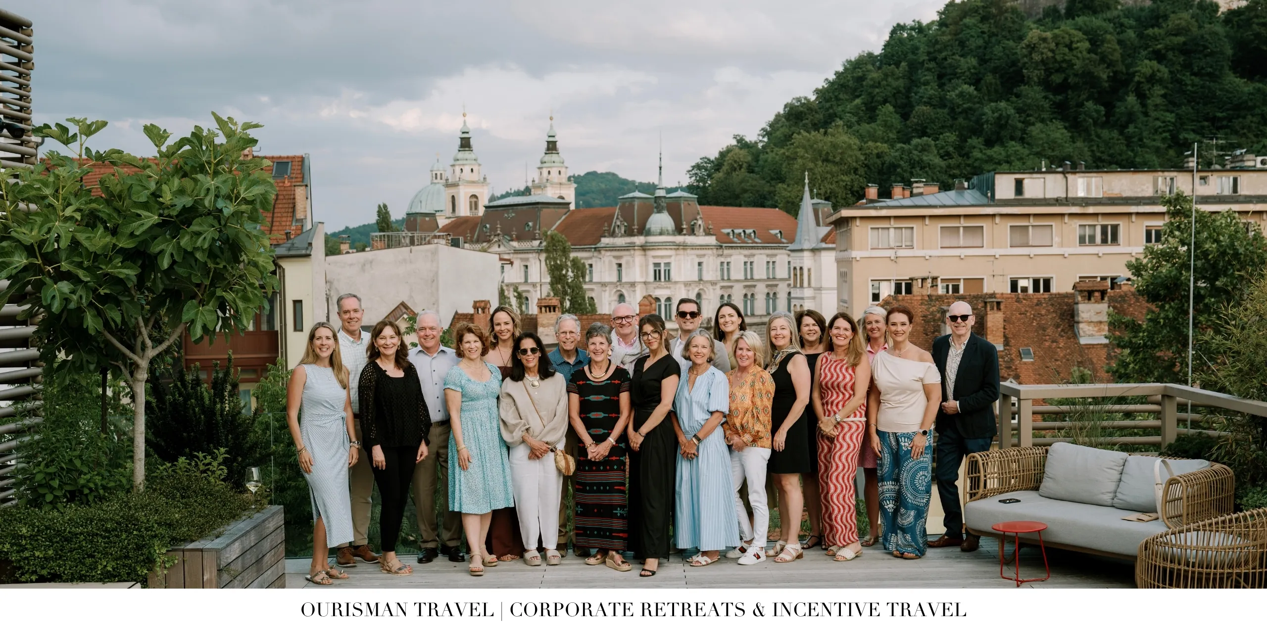 Corporate incentive travel group gathered on a rooftop terrace overlooking a historic city