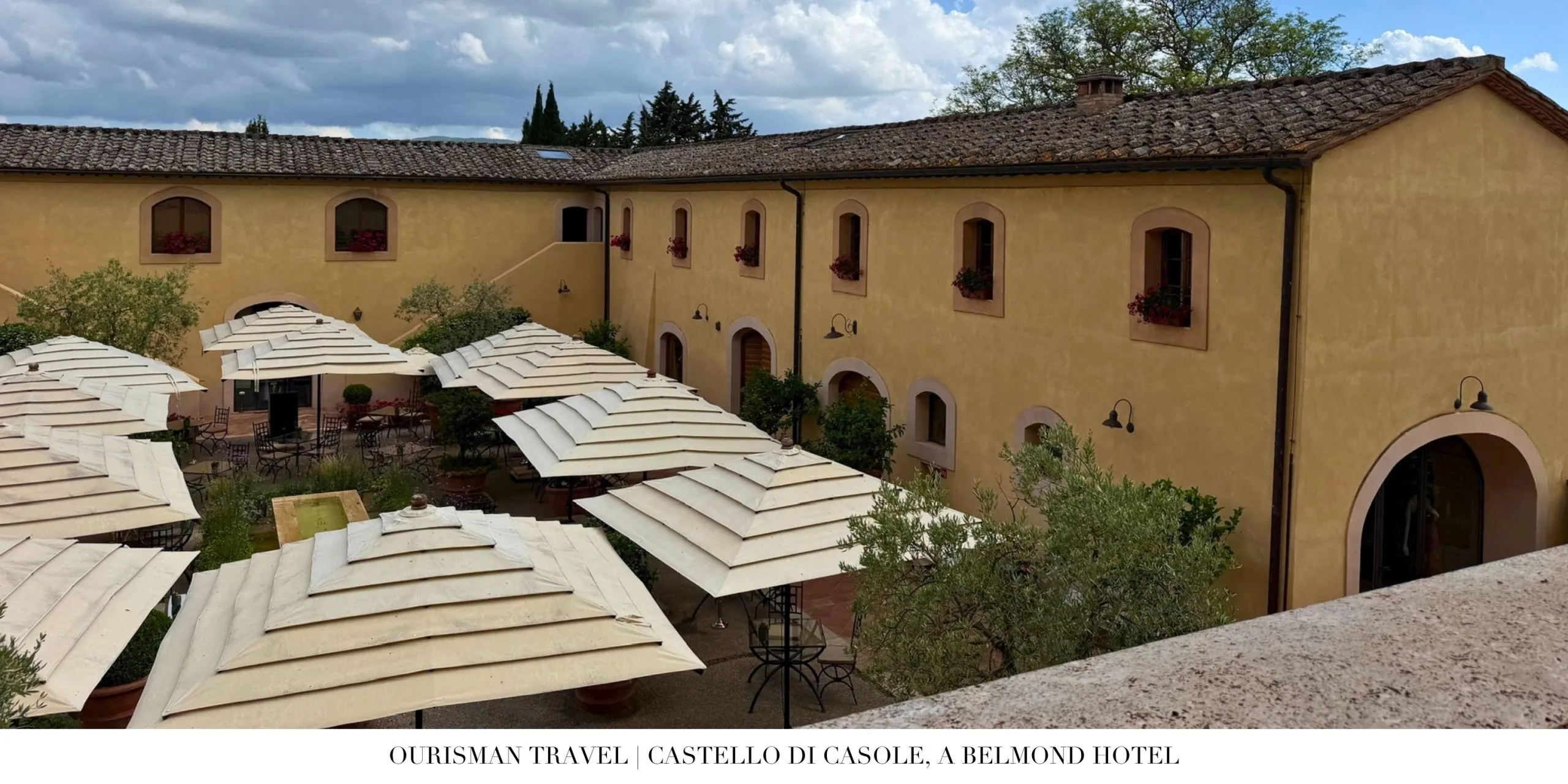 Courtyard buildings at Castello di Casole, a Belmond Hotel, overlooking the Tuscan countryside.