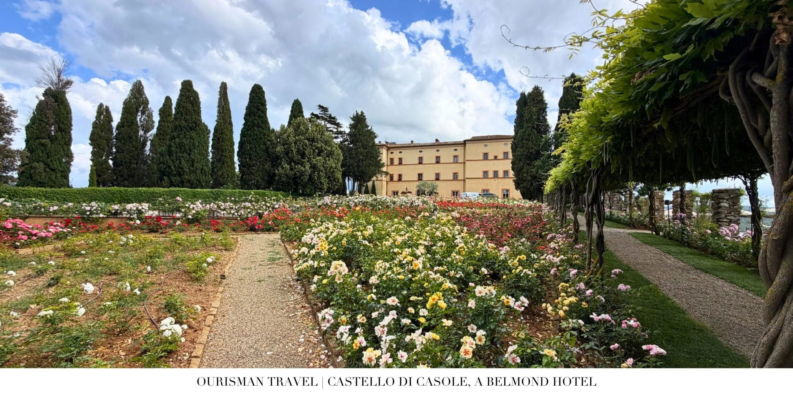 Flower gardens with views of Castello di Casole, a Belmond Hotel, in the Tuscan countryside.